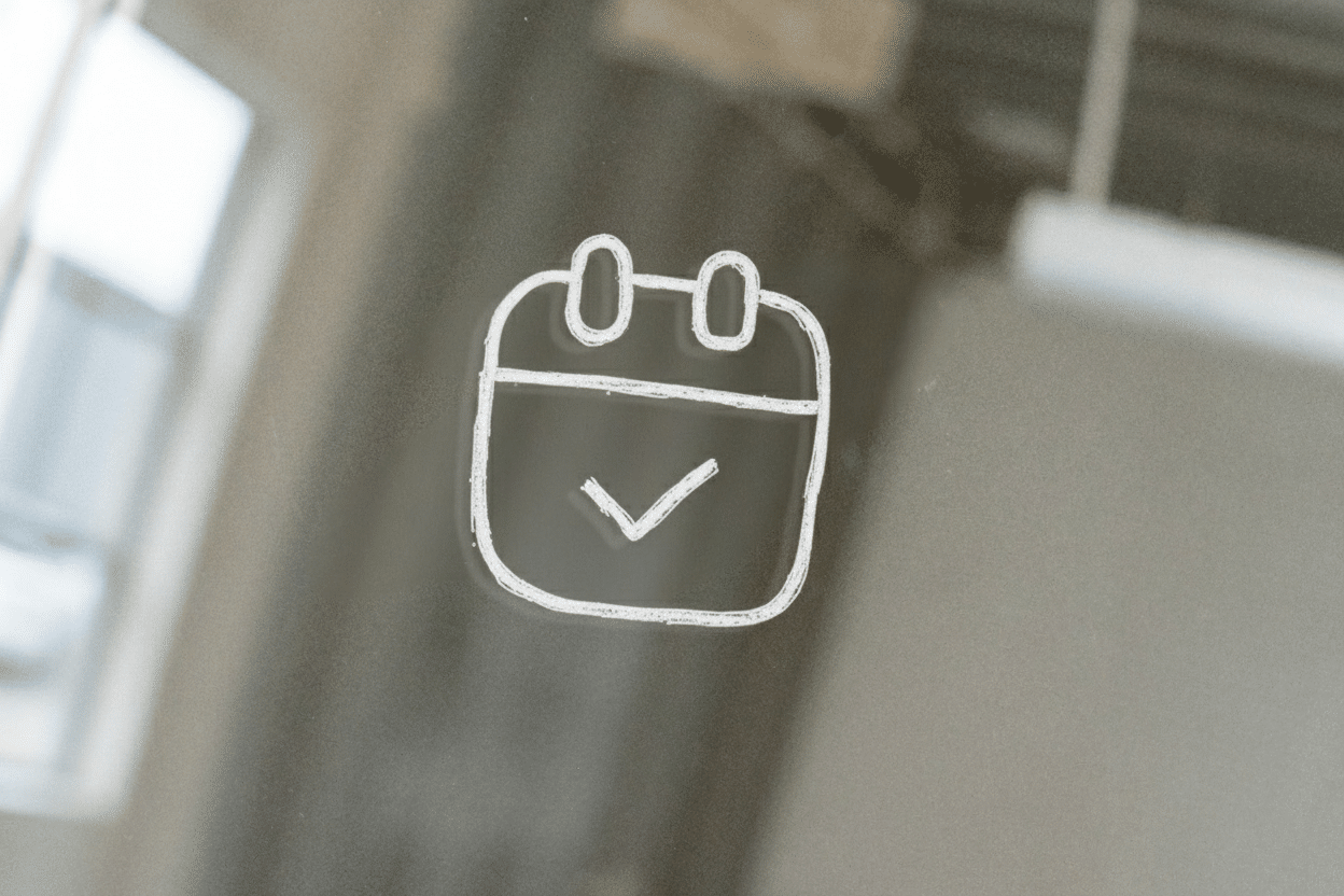 Witte tekening van een kalendericoon met een vinkje op glas.